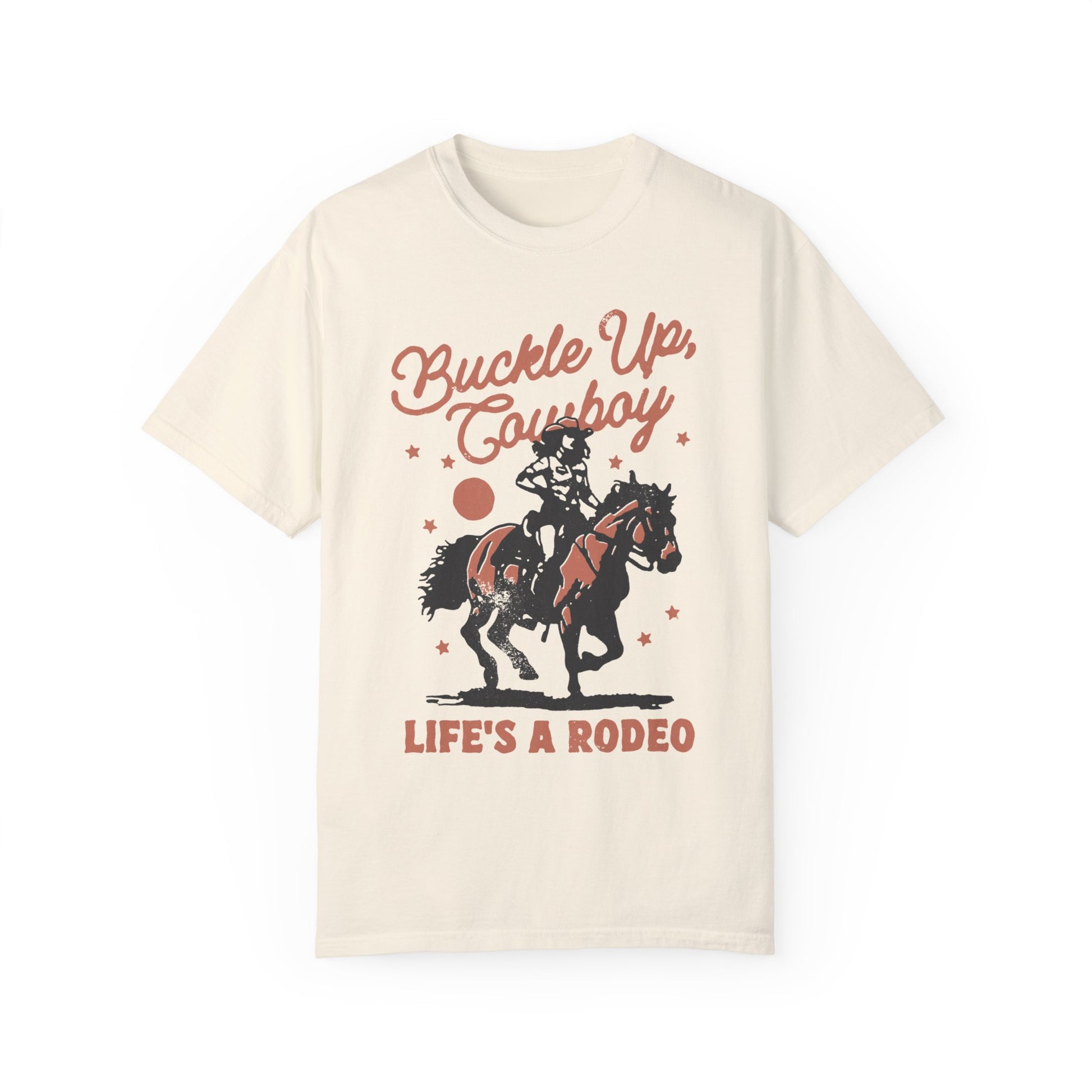 This Shirt Says "Buckle Up Cowboy, Life's a Rodeo" It's a Ivory Cowgirl Graphic T-Shirt With A Girl Riding A Horse